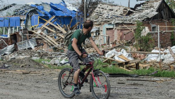 A local citizen rides a bicycle past destroyed houses after heavy fighting between independence supporters and Ukrainian government troops just outside Slovyansk, eastern Ukraine, Wednesday, July 9, 2014 A local citizen rides a bicycle past destroyed houses after heavy fighting between independence supporters and Ukrainian government troops just outside Slovyansk, eastern Ukraine, Wednesday, July 9, 2014 - Sputnik International