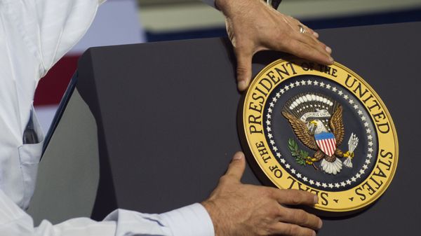 An aide places the Presidential seal on the podium prior to US President Barack Obama speaking during a campaign event at Kissimmee Civic Center in Kissimmee, Florida An aide places the Presidential seal on the podium prior to US President Barack Obama speaking during a campaign event at Kissimmee Civic Center in Kissimmee, Florida - Sputnik International