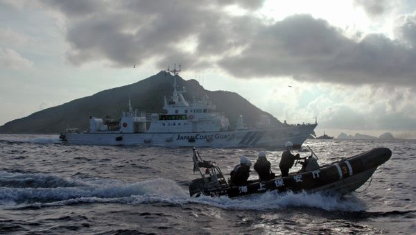 Japanese Coast Guard boat and vessel sail alongside Japanese activists' fishing boat, not in photo, warning the activists away from a group of disputed islands called Diaoyu by China and Senkaku by Japan - Sputnik International
