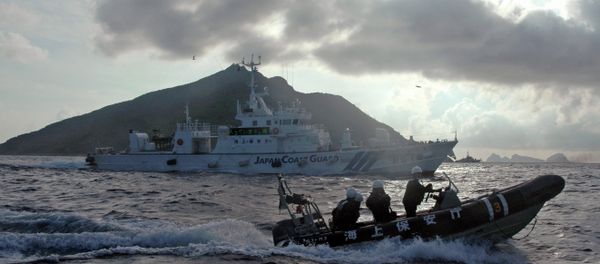 Japanese Coast Guard boat and vessel sail alongside Japanese activists' fishing boat, not in photo, warning the activists away from a group of disputed islands called Diaoyu by China and Senkaku by Japan Japanese Coast Guard boat and vessel sail alongside Japanese activists' fishing boat, not in photo, warning the activists away from a group of disputed islands called Diaoyu by China and Senkaku by Japan - Sputnik International