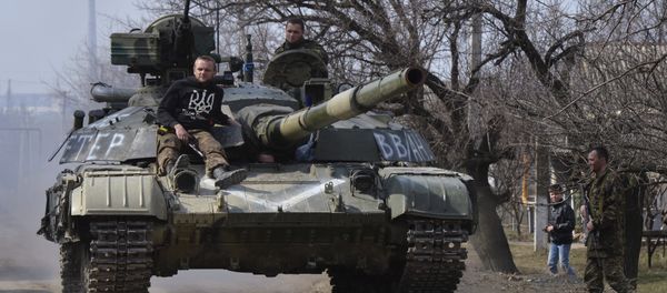 Members of the Ukrainian armed forces drive a tank in the settlement of Luhanske, Donetsk region, March 27, 2015 Members of the Ukrainian armed forces drive a tank in the settlement of Luhanske, Donetsk region, March 27, 2015 - Sputnik International