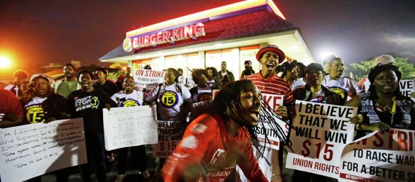 Joshua Collins, center, chants during a protest outside a Burger King restaurant by fast-food workers and activists calling for the federal minimum wage to be raised to $15, Wednesday, April 15, 2015, in College Park, Ga. Organizers say they chose April 15, tax day, to demonstrate because they want the public to know that many low-wage workers must rely on public assistance to make ends meet. Joshua Collins, center, chants during a protest outside a Burger King restaurant by fast-food workers and activists calling for the federal minimum wage to be raised to $15, Wednesday, April 15, 2015, in College Park, Ga. Organizers say they chose April 15, tax day, to demonstrate because they want the public to know that many low-wage workers must rely on public assistance to make ends meet. - Sputnik International
