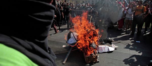 A masked demonstrator stands next to a pile of debris set on fire during a protest near La Moneda Palace in Santiago, Chile, Thursday, April 16, 2015. Thousands of students marched through the streets of Chile’s capital to protest recent corruption scandals and to complain about delays in a promised education overhaul. While it was largely peaceful, violence broke out at the end when hooded protesters threw rocks and gasoline bombs at police. At least one officer was injured. A masked demonstrator stands next to a pile of debris set on fire during a protest near La Moneda Palace in Santiago, Chile, Thursday, April 16, 2015. Thousands of students marched through the streets of Chile’s capital to protest recent corruption scandals and to complain about delays in a promised education overhaul. While it was largely peaceful, violence broke out at the end when hooded protesters threw rocks and gasoline bombs at police. At least one officer was injured. - Sputnik International