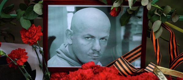 Flowers and candles laid at the Ukraine Embassy in Moscow in memory of journalist Oles Buzina killed in Kiev - Sputnik International