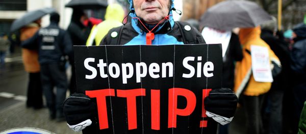 A protester holds up a sign, reading: Stop TTIP! (Transatlantic Trade and Investment Partnership) A protester holds up a sign, reading: Stop TTIP! (Transatlantic Trade and Investment Partnership) - Sputnik International