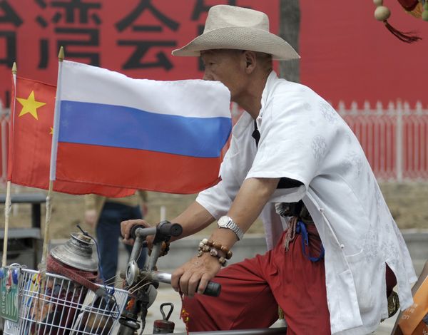 A man rides with a Russian flag displayed on his pedicab in Beijing's Russian trade district of Yabaolu. (File) A man rides with a Russian flag displayed on his pedicab in Beijing's Russian trade district of Yabaolu. (File) - Sputnik International