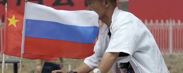 A man rides with a Russian flag displayed on his pedicab in Beijing's Russian trade district of Yabaolu. file photo A man rides with a Russian flag displayed on his pedicab in Beijing's Russian trade district of Yabaolu. file photo - Sputnik International