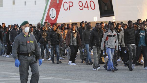 Migrants are disembarked from a Coast Guard boat in the Sicilian harbour of Augusta Migrants are disembarked from a Coast Guard boat in the Sicilian harbour of Augusta - Sputnik International