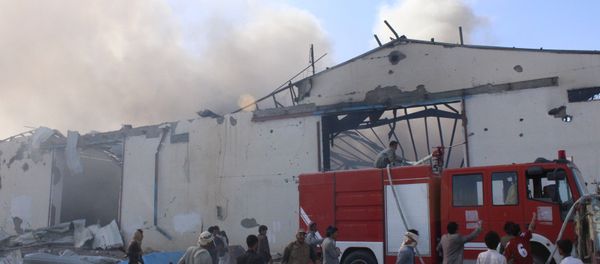 Civil defence workers try to put out the fire caused by an air strike on a food stuff depot in Yemen's northwestern city of Saada April 18, 2015 - Sputnik International