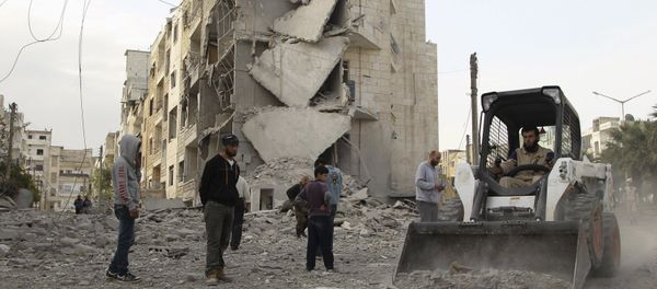 A man operates a front loader as he removes debris at a site hit by what activists said were barrel bombs dropped by forces of Syria's President Bashar al-Assad, at al-Thawra neighborhood in Idlib city April 20, 2015 A man operates a front loader as he removes debris at a site hit by what activists said were barrel bombs dropped by forces of Syria's President Bashar al-Assad, at al-Thawra neighborhood in Idlib city April 20, 2015 - Sputnik International