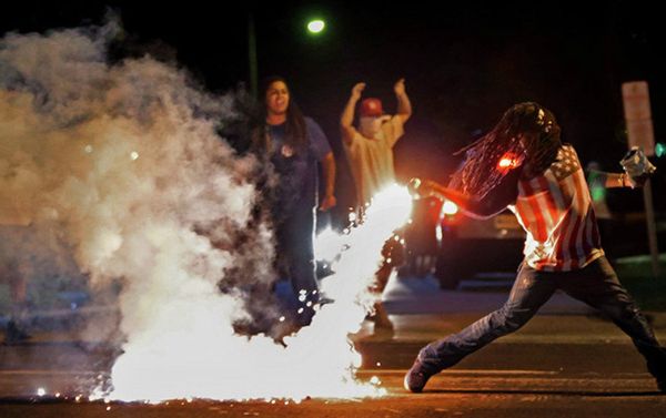 This August 13, 2014, photo by St. Louis Post Dispatch photographer Robert Cohen shows Edward Crawford returning a tear gas canister fired by police who were trying to disperse protesters in Ferguson, Missouri This August 13, 2014, photo by St. Louis Post Dispatch photographer Robert Cohen shows Edward Crawford returning a tear gas canister fired by police who were trying to disperse protesters in Ferguson, Missouri - Sputnik International