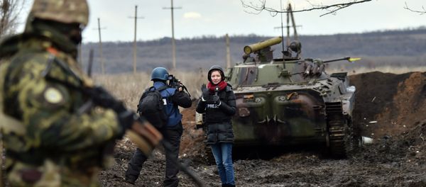 A TV journalist prepares to do a piece to camera in front of an armoured personnel carrier (APC) on the frontline between Ukrainian forces and militants near the eastern Ukrainian city of Debaltseve, in the Donetsk region - Sputnik International