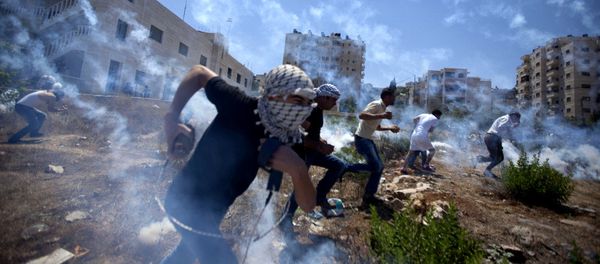 Palestinians run for cover during clashes with Israeli soldiers following a protest against the war in the Gaza Strip in August 2014. - Sputnik International