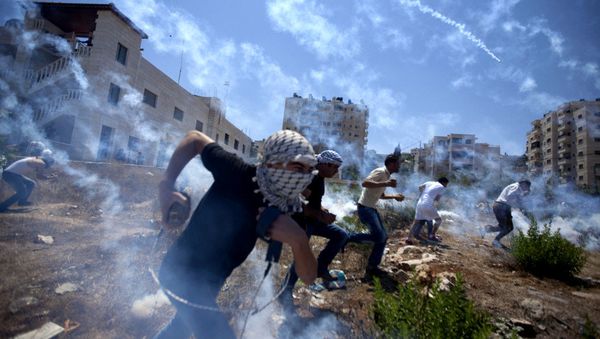 Palestinians run for cover during clashes with Israeli soldiers following a protest against the war in the Gaza Strip in August 2014. Palestinians run for cover during clashes with Israeli soldiers following a protest against the war in the Gaza Strip in August 2014. - Sputnik International