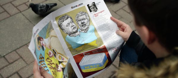 Young man reading a caricature newspaper - Sputnik International