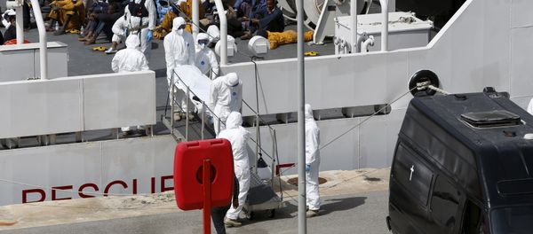 Armed Forces of Malta personnel in protective clothing carry the body of a dead immigrant off Italian coastguard ship Bruno Gregoretti as surviving migrants watch in Senglea, in Valletta's Grand Harbour, April 20, 2015 - Sputnik International
