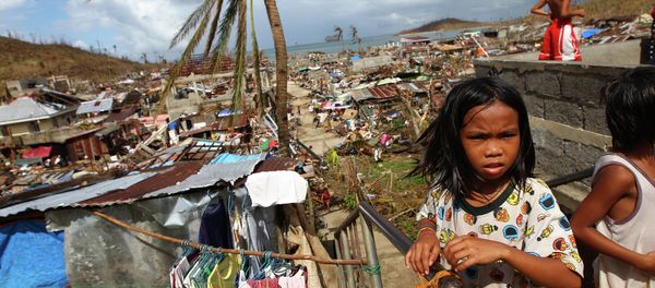 Filipino children play as houses damaged by Typhoon Haiyan are seen in the background in Marabut, Philippines in 2013. Filipino children play as houses damaged by Typhoon Haiyan are seen in the background in Marabut, Philippines in 2013. - Sputnik International