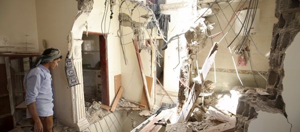A man looks at damage in his house caused by an April 20 air strike that hit a nearby army weapons depot in Sanaa April 21, 2015 - Sputnik International