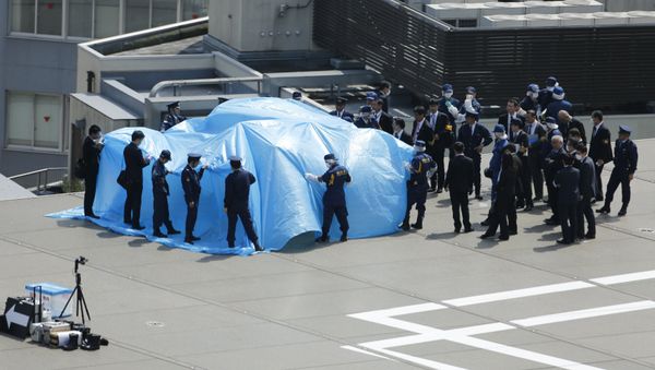Police and security officials stand around a tarpaulin covering a drone on the roof of Prime Minister Shinzo Abe's official residence in Tokyo April 22, 2015 - Sputnik International