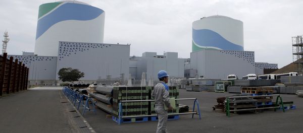 An employee of Kyushu Electric Power Co walks in front of reactor buildings at the company's Sendai nuclear power plant in Satsumasendai, Kagoshima prefecture - Sputnik International
