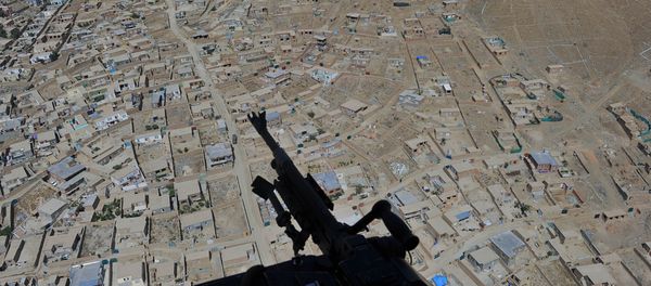 Residential houses and a mounted machine gun manned by an Afghan National Army soldier is pictured during a helicopter flight  - Sputnik International