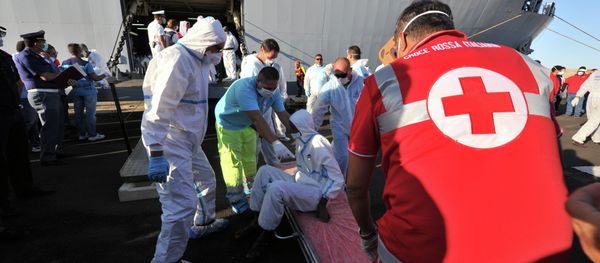 Rescuers take care of an immigrant, part of a group of more than 1,370 people, after he disembarked from the Italian military ship San Giusto on August 25, 2014 in the port of Crotone, southern Italy, following the Mare Nostrum rescue operations at sea Rescuers take care of an immigrant, part of a group of more than 1,370 people, after he disembarked from the Italian military ship San Giusto on August 25, 2014 in the port of Crotone, southern Italy, following the Mare Nostrum rescue operations at sea - Sputnik International