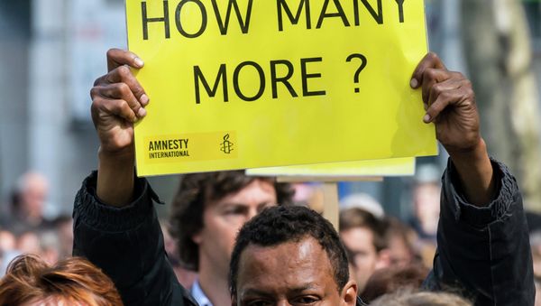 A protestor holds up a sign during a demonstration outside of an emergency EU summit in Brussels. A protestor holds up a sign during a demonstration outside of an emergency EU summit in Brussels. - Sputnik International