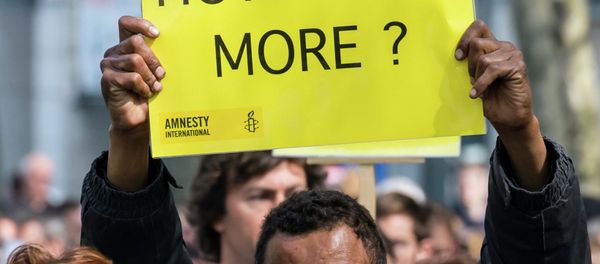 A protestor holds up a sign during a demonstration outside of an emergency EU summit in Brussels. - Sputnik International