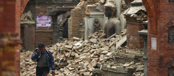 A man cries as he walks on the street while passing through a damaged statue of Lord Buddha a day after an earthquake in Bhaktapur, Nepal A man cries as he walks on the street while passing through a damaged statue of Lord Buddha a day after an earthquake in Bhaktapur, Nepal - Sputnik International
