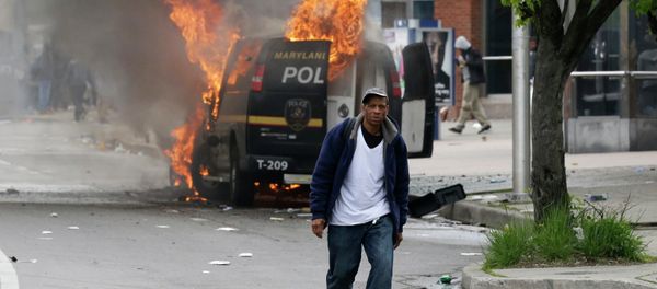 A man walks past a burning police vehicle, Monday, April 27, 2015, during unrest following the funeral of Freddie Gray in Baltimore. Gray died from spinal injuries about a week after he was arrested and transported in a Baltimore Police Department van. A man walks past a burning police vehicle, Monday, April 27, 2015, during unrest following the funeral of Freddie Gray in Baltimore. Gray died from spinal injuries about a week after he was arrested and transported in a Baltimore Police Department van. - Sputnik International