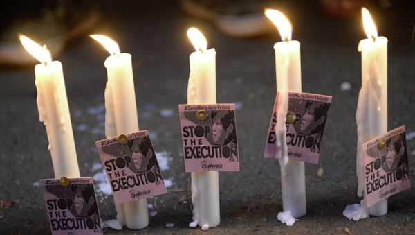 Candles and portraits of Filipina Mary Jane Veloso, who is due for execution in Indonesia, are seen during the vigil in front of the Indonesian embassy in Manila on April 27, 2015. - Sputnik International