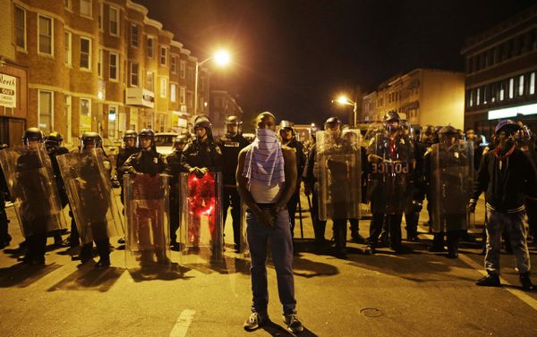 A man stands in front of a line of police officers in riot gear as part of a community effort to disperse the crowd ahead of a 10 p.m. curfew in the wake of Monday's riots following the funeral for Freddie Gray, Tuesday, April 28, 2015, in Baltimore. A man stands in front of a line of police officers in riot gear as part of a community effort to disperse the crowd ahead of a 10 p.m. curfew in the wake of Monday's riots following the funeral for Freddie Gray, Tuesday, April 28, 2015, in Baltimore. - Sputnik International
