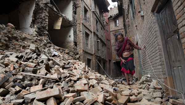 A woman walks across the rubble of a collapsed building following an earthquake in Bhaktapur near Kathmandu, Nepal in this Red Cross handout picture taken on April 28, 2015. A woman walks across the rubble of a collapsed building following an earthquake in Bhaktapur near Kathmandu, Nepal in this Red Cross handout picture taken on April 28, 2015. - Sputnik International