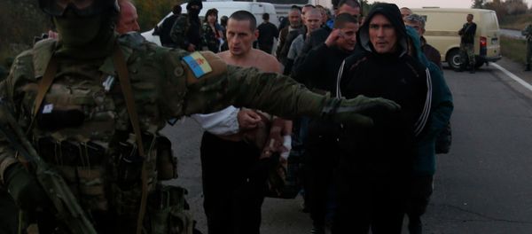 An Ukrainian soldier guards members of the Pro-Russian forces, who are prisoners-of-war, during prisoners exchange near the town of Donetsk, eastern Ukraine, Sunday, Sept. 28, 2014 An Ukrainian soldier guards members of the Pro-Russian forces, who are prisoners-of-war, during prisoners exchange near the town of Donetsk, eastern Ukraine, Sunday, Sept. 28, 2014 - Sputnik International