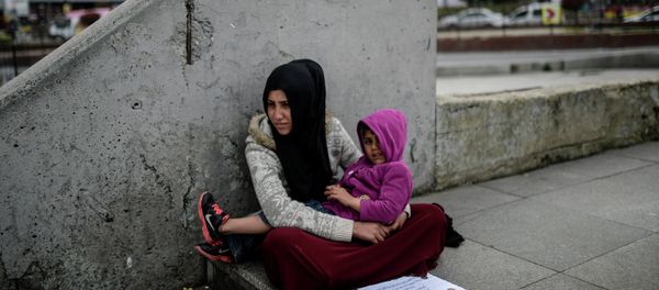 Syrian refugee woman begs as she sits with a child at Eminonu in Istanbul on April 14, 2015 - Sputnik International