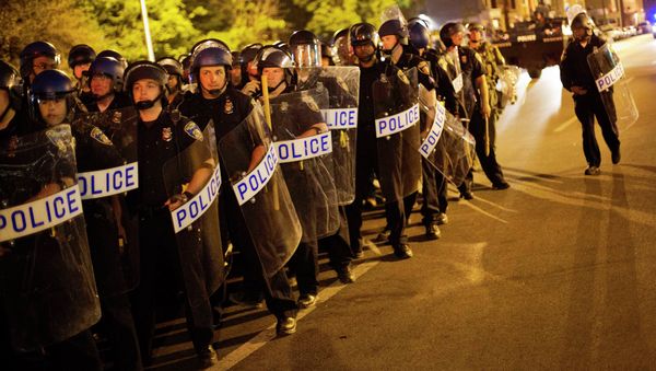 Police in riot gear line up near the scene of Monday's riots ahead of a 10 p.m. curfew Wednesday, April 29, 2015, in Baltimore. The curfew was imposed after unrest in Baltimore over the death of Freddie Gray while in police custody. Police in riot gear line up near the scene of Monday's riots ahead of a 10 p.m. curfew Wednesday, April 29, 2015, in Baltimore. The curfew was imposed after unrest in Baltimore over the death of Freddie Gray while in police custody. - Sputnik International