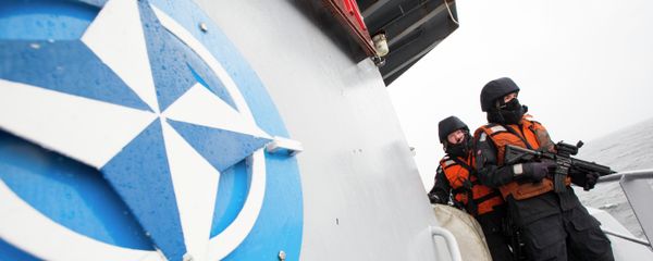 Two Norwegian sailors onboard the Norwegian support vessel Valkyrien pose for photographers next to the NATO logo - Sputnik International