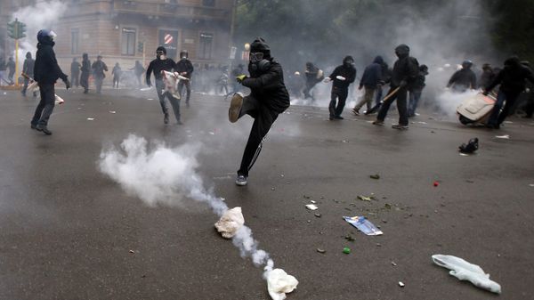 A demonstrators kicks a teargas canister as clashes broke out with Italian Policemen during a protest against the Expo 2015 fair in Milan, Italy, Friday, May 1, 2015 - Sputnik International