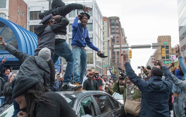 A demonstrator puts on a Baltimore City Police hat taken from a destroyed police car while protesting the death Freddie Gray, an African American man who died of spinal cord injuries in police custody, in Baltimore, Maryland, April 25, 2015 - Sputnik International