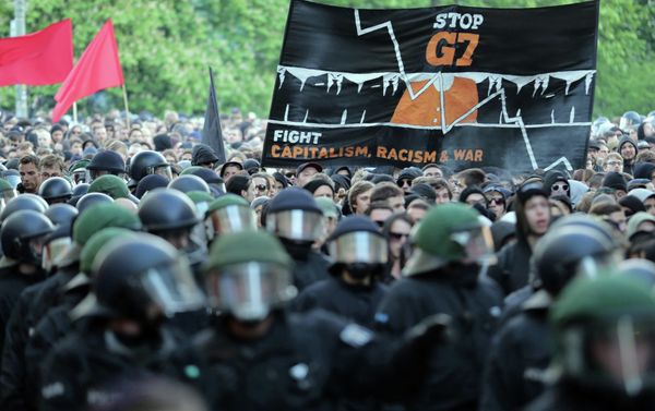 Protesters hold a banner reading ' Stop G7 - Fight Capitalism, Racism and War' as they take part in the 'Revolutionary' May Day demonstration in Berlin's Kreuzberg district on May 1, 2015 Protesters hold a banner reading ' Stop G7 - Fight Capitalism, Racism and War' as they take part in the 'Revolutionary' May Day demonstration in Berlin's Kreuzberg district on May 1, 2015 - Sputnik International