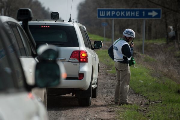 An OSCE observer speaks via radio, in front of the sign saying Shyrokyne, near the village of Shyrokyne, eastern Ukraine An OSCE observer speaks via radio, in front of the sign saying Shyrokyne, near the village of Shyrokyne, eastern Ukraine - Sputnik International