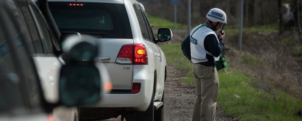 An OSCE observer speaks via radio, in front of the sign saying Shyrokyne, near the village of Shyrokyne, eastern Ukraine An OSCE observer speaks via radio, in front of the sign saying Shyrokyne, near the village of Shyrokyne, eastern Ukraine - Sputnik International