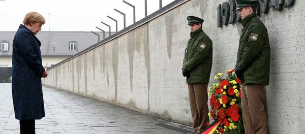 German Chancellor Angela Merkel observes a moment of silence as she lays a wreath during a ceremony at the memorial in the former German Nazi concentration camp in Dachau near Munich, Germany May 3, 2015 - Sputnik International