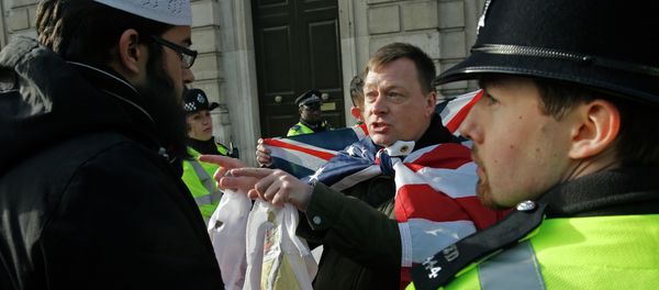 A Muslim demonstrator (L) speaks with an opposing nationalist demonstration group, as police stand by, near Downing Street in central London A Muslim demonstrator (L) speaks with an opposing nationalist demonstration group, as police stand by, near Downing Street in central London - Sputnik International