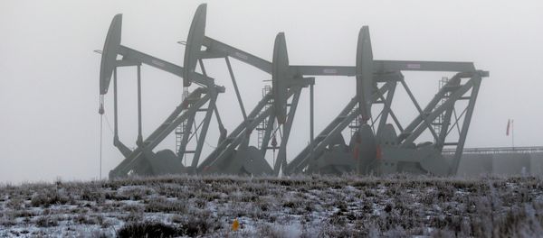 Oil pump jacks work in unison on a foggy morning in Williston, N.D - Sputnik International