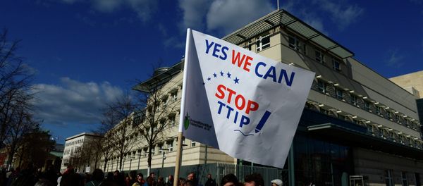 Anti-TTIP-demonstrators hold a banner reading Yes we can stop TTIP! as they form a human chain in front of the US embassy to protest against the proposed US-EU free trade pact or Transatlantic Trade and Investment Partnership at Potsdamer Platz in Berlin - Sputnik International