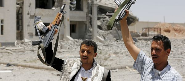 Houthi militants gesture in the yard of the residence of the military commander of the Houthi militant group, Abdullah Yahya al Hakim, after it was hit by an airstrike, in Sanaa April 28, 2015 - Sputnik International