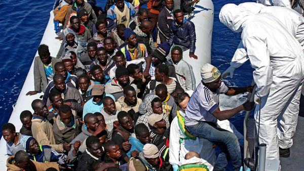 Migrants crowd and inflatable dinghy as rescue vassel Denaro of the Italian Coast Guard approaches them, off the Libyan coast, in the Mediterranean Sea, Wednesday, April 22, 2015 Migrants crowd and inflatable dinghy as rescue vassel Denaro of the Italian Coast Guard approaches them, off the Libyan coast, in the Mediterranean Sea, Wednesday, April 22, 2015 - Sputnik International