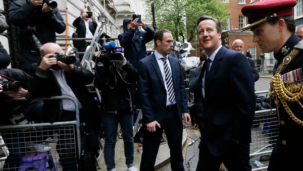 Britain's Prime Minister David Cameron, left, leaves 10 Downing Street in London with a soldier, to attend a VE Day service at the Cenotaph, Friday, May 8, 2015 - Sputnik International