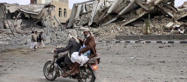 People ride on a motorcycle as they pass by a police headquarters destroyed by a Saudi-led air strike in Yemen's northwestern city of Saada May 7, 2015 People ride on a motorcycle as they pass by a police headquarters destroyed by a Saudi-led air strike in Yemen's northwestern city of Saada May 7, 2015 - Sputnik International